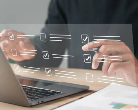 Hands pointing at laptop screen with floating digital checklist interface showing checkboxes and lines, representing the interactive process of completing an online mental health assessment