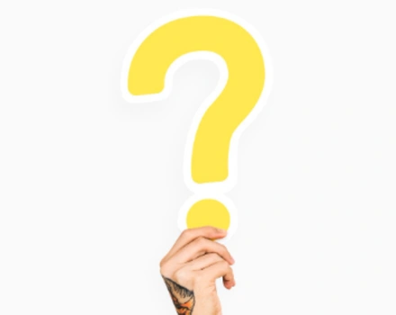 Hand holding up large yellow question mark against white background, symbolizing curiosity and the process of seeking answers about mental health assessments and treatment options