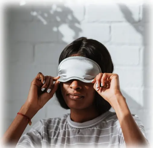 Image of a woman putting her sleeping mask getting ready for here ketamine session.